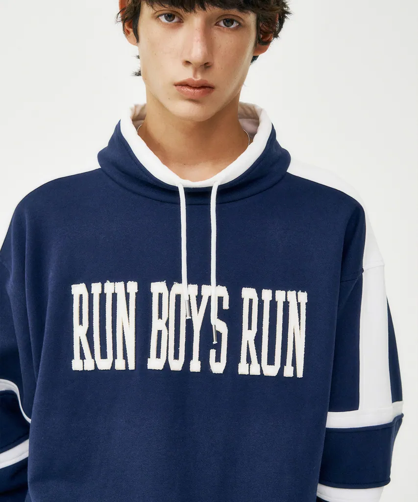 네이비 하이넥 스웻셔츠. 화이트 넥 라인과 소매 화이트 배색 띠, 가슴에 아치형 RUN BOYS RUN 레터링