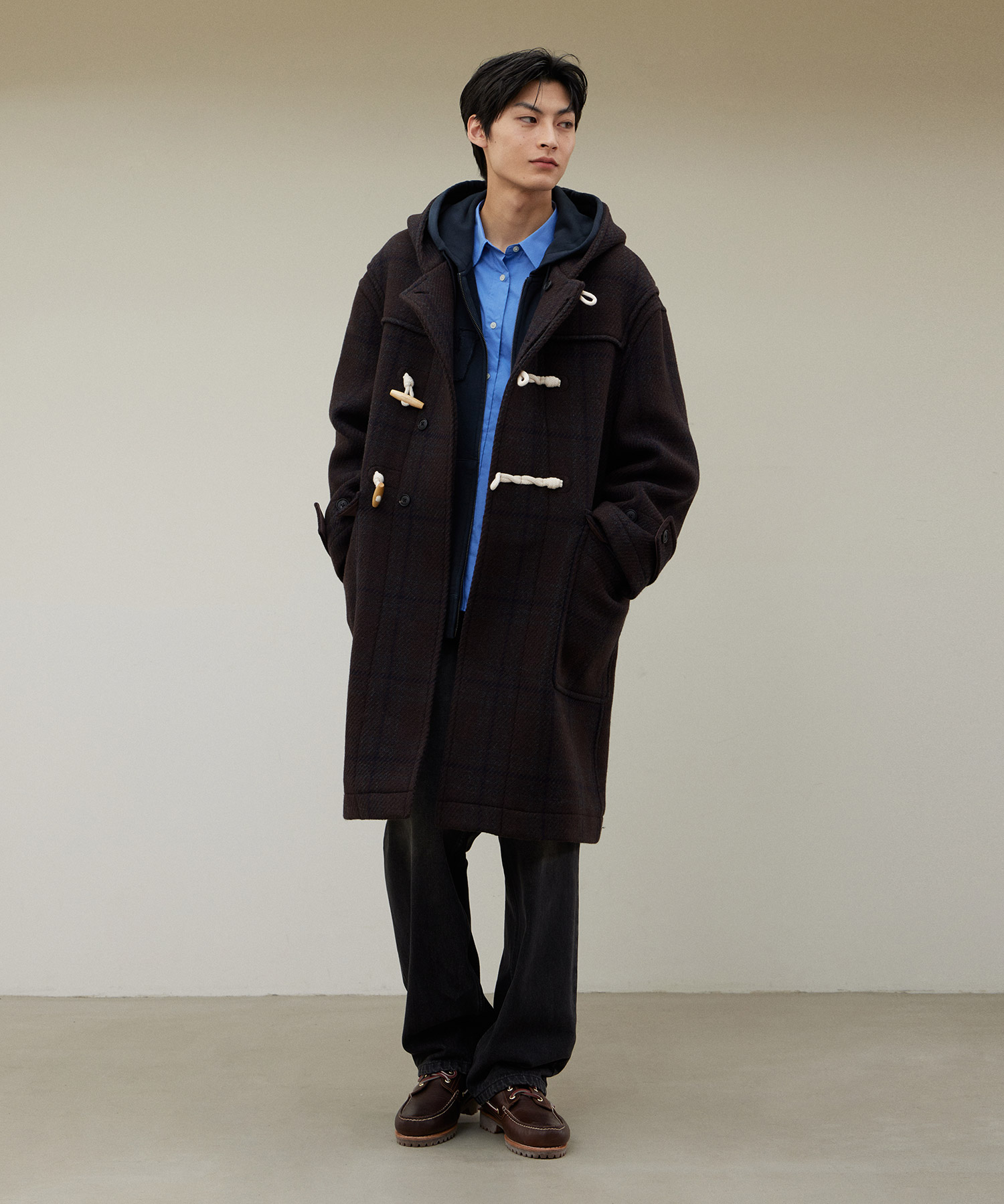 짙은 초콜릿 브라운 바탕에 톤온톤 체크가 은은하게 비치는 무릎 아래 기장 후드 더플 코트. 크림색 로프 고리에 우드 토글 여밈, 후드와 소매 끝에 비조