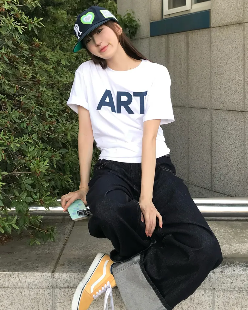 강유석이 가슴에 네이비 'ART' 레터링이 크게 들어간 흰 오버핏 반팔 티셔츠를 입고 식사한다.