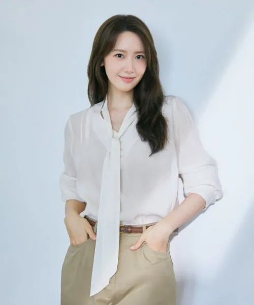 아이보리 컬러의 브이넥 블라우스. 목 앞에서 길게 떨어지는 스카프형 타이가 달려 있고 앞면은 단추 여밈, 소매는 넉넉하게 떨어진다