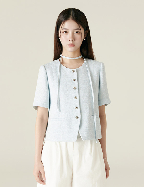최종선택을 앞두고 숙소에서 식사하는 장면에 입은 연하늘색 칼라리스 트위드 반팔 재킷. 라운드 네크라인에 같은 원단 타이 스트랩이 달려 있고 앞판 금속 버튼 6개, 허리 양쪽 웰트 포켓