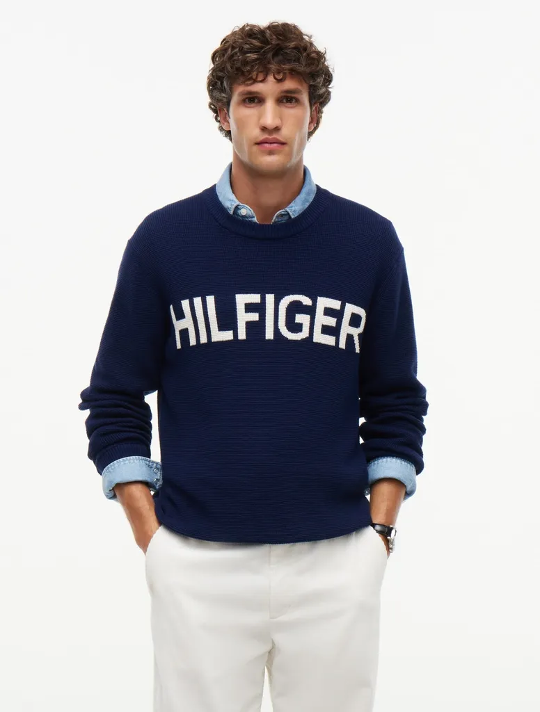 네이비 와플 조직 니트 가슴 전면에 대형 화이트 HILFIGER 일자 레터링이 들어간 크루넥 스웨터.