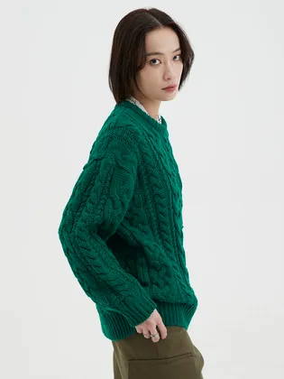 진한 그린 꽈배기 케이블 니트 스웨터. 둥근 목선에 굵은 케이블이 전체에 들어간다